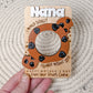 A hand holding a fridge photo magnet designed for Mother's Day, featuring a wooden frame with a cut-out shape of a cookie and the text 'MAMA, TOTALLY WOULD CRUMBLE WITHOUT YOU'.
