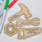 A set of wooden tools with magnets, including shapes of a saw, hammer, wrench, and nut, alongside markers for coloring.