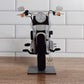A motorcycle-shaped eyeglasses holder, with a black seat and silver metallic parts, displayed on a stand.