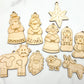 A collection of wooden nativity scene ornaments including figures of Mary, Joseph, baby Jesus, shepherds, and animals, along with a star and a donkey.